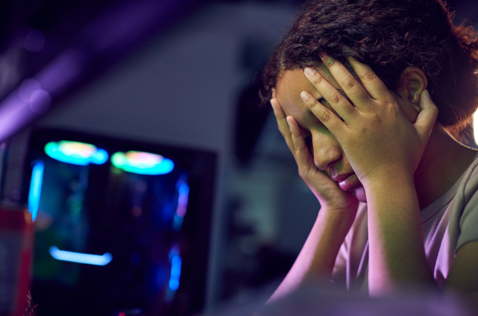 Stressed Teenage Girl Being Bullied Online Whilst Gaming At Home|